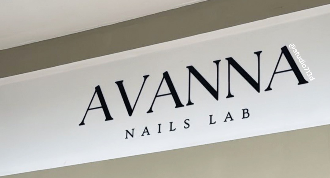 Logotipo negro aplicado con vinil sobre muro blanco